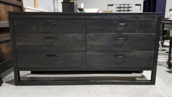 Black metal dresser with multiple drawers in a showroom setting