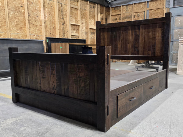 Wooden bed frame with storage drawers in a warehouse setting