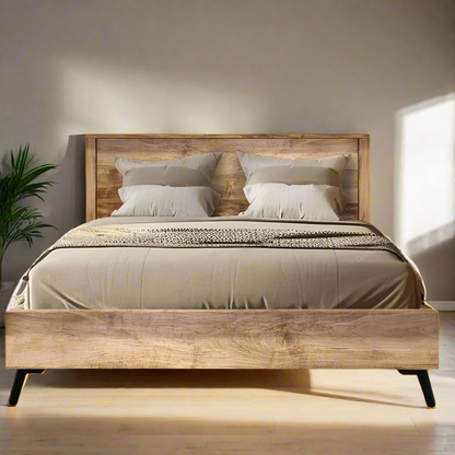 Wooden bed with beige bedding against a plain wall